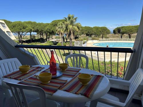 - une table sur un balcon avec vue sur la piscine dans l'établissement Studio 2 couchages à Port Camargue, vue mer - FR-1-250-301, au Grau-du-Roi