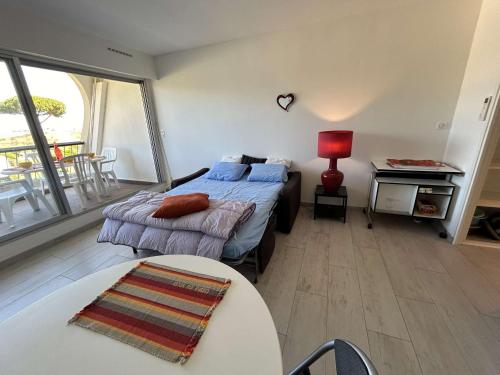 une chambre avec un lit, un bureau et une table dans l'établissement Studio 2 couchages à Port Camargue, vue mer - FR-1-250-301, au Grau-du-Roi