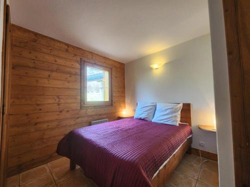 - une chambre avec un lit et un mur en bois dans l'établissement Bel appartement 4 pièces avec vue montagne et Wifi à Samoëns - FR-1-629-146, à Samoëns