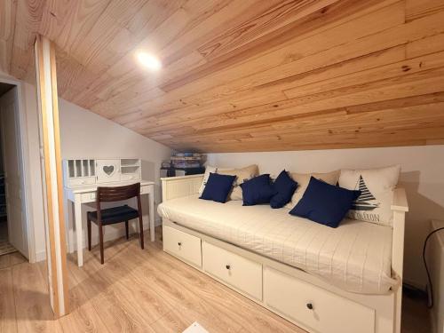 - une chambre avec un lit doté d'oreillers bleus et d'un bureau dans l'établissement Ancien chai rénové à Oléron, idéal familles, proche mer - FR-1-778-46, à Saint-Pierre-dʼOléron
