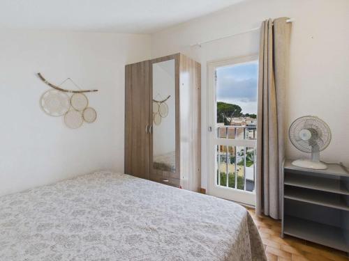 - une chambre avec un lit et une fenêtre avec un ventilateur dans l'établissement Appartement 2 pièces proche plage avec parking à Grau d'Agde - FR-1-423-317, au Grau-dʼAgde