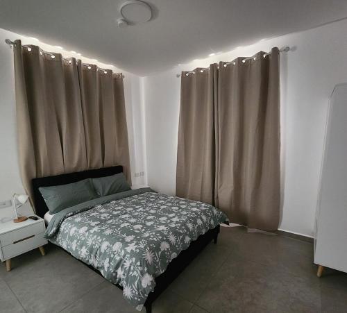エイラットにあるUrban Suite Neve Tzedek Eilatのベッドルーム1室(ベッド1台、カーテン付)