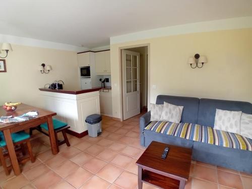 un salon avec un canapé bleu et une table dans l'établissement Appartement T3 à Soustons plage - Animaux admis - FR-1-239-1109, à Soustons
