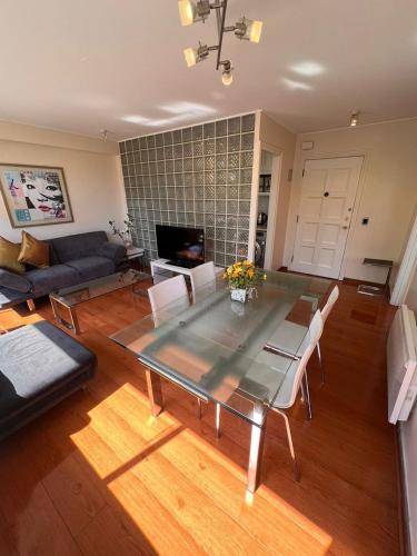 a living room with a glass table and chairs at II Orly Suites Pedro de Valdivia 0200 in Santiago