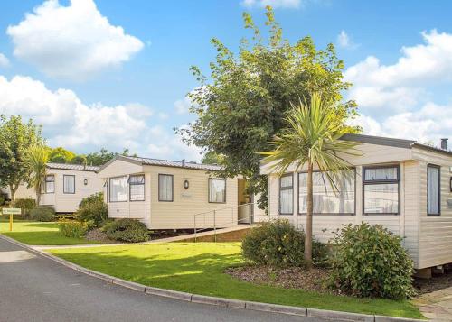 a house with a palm tree in front of a street at Fishguard Holiday Park in Pembrokeshire