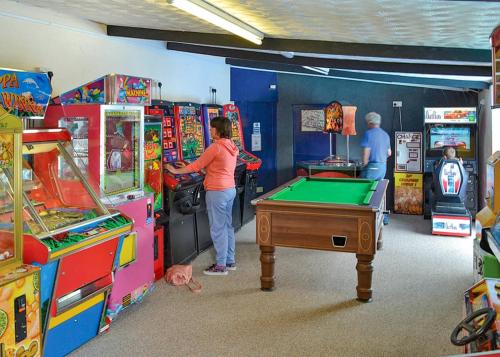 a woman playing a video game in a arcade at Fishguard Holiday Park in Pembrokeshire