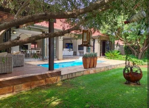 una casa con patio con piscina en Pecanwood Estate Luxury Villa 5 bedrooms with pool, en Hartbeespoort