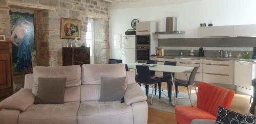 un salon avec un canapé et une table avec des chaises dans l'établissement Le Patio de St Antonin, à Saint-Antonin