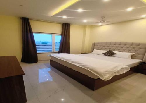 a bedroom with a large bed and a window at Hotel R.Raghavam in Ayodhya