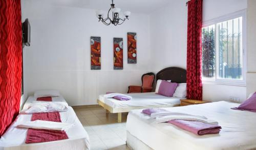 a room with two beds and a window at City Center Apartments in Haifa