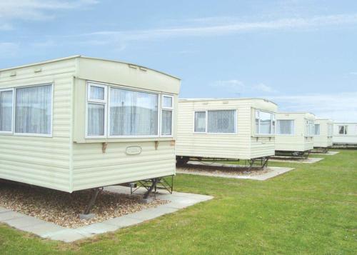 a row of mobile homes parked in a field at Golden Anchor Caravan Park in Chapel Saint Leonards