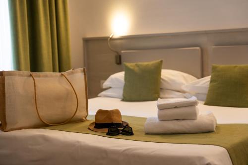 a hotel room with towels and a hat on a bed at Spa Hotel Splendid Sole in Manerba del Garda