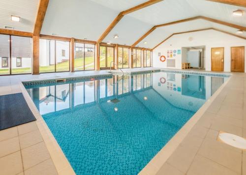 ein großes Schwimmbad in einem Gebäude mit einem großen Schwimmbad in der Unterkunft Green Acres Cottages in Par