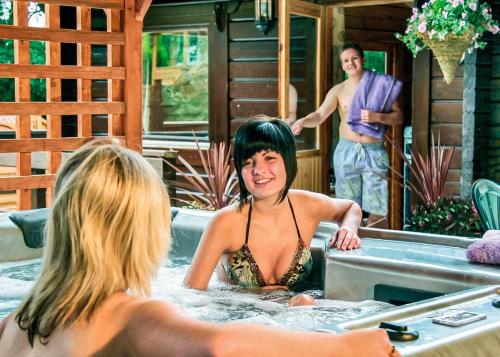 a woman sitting in a bathtub with a man at Heronstone Lodges in Ystalyfera
