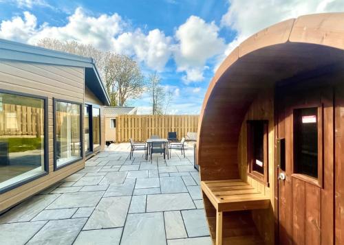 an outdoor patio with a table and chairs at Hamlet Lodge Retreat At Calloose Holiday Park in Hayle