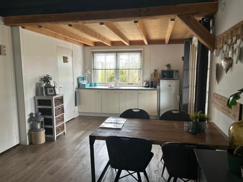 a kitchen and dining room with a table and chairs at Warmhuisje in Warmenhuizen