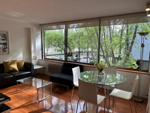 a living room with a glass table and chairs at II Orly Suites Pedro de Valdivia 0200 in Santiago