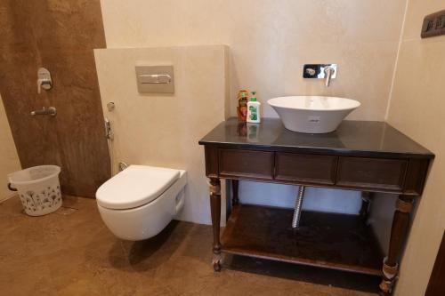 a bathroom with a white toilet and a sink at Conifer Resort in Jajal