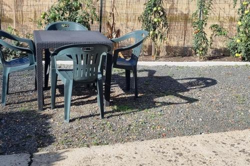 a table with three chairs and a table with at Appartement au coeur du perche in Val-au-Perche