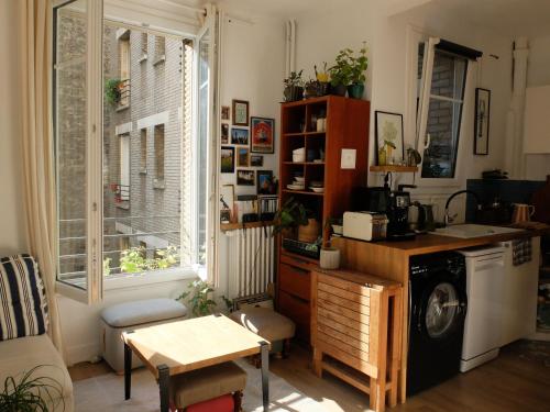 une cuisine avec une table et une machine à laver dans l'établissement Confort & calme, appartement hypercentre Paris, à Paris