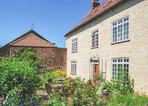 an old brick house with a garden in front of it at Home Farm in Stillingfleet