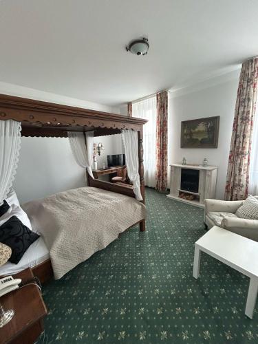 a bedroom with a large bed and a couch at Hotel Uckermark in Prenzlau