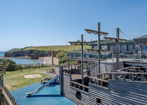a building with a playground with a slide at Ladram Bay Holiday Park in Otterton