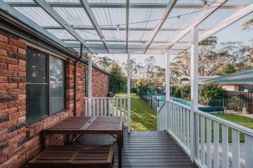 a pergola on a porch with a wooden bench at Retreat, Relax, Repeat in Katoomba, Blue Mountains in Katoomba