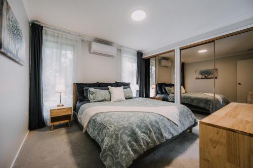a bedroom with a bed and a large window at Retreat, Relax, Repeat in Katoomba, Blue Mountains in Katoomba