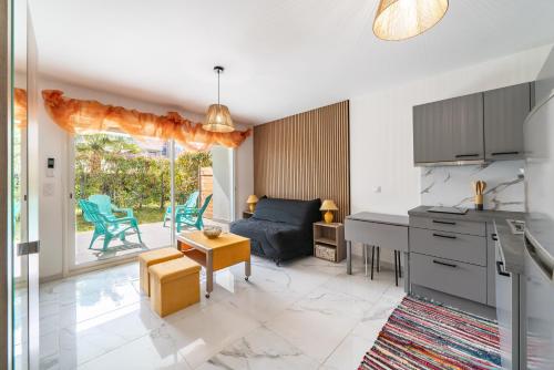 une cuisine et un salon avec un canapé et une table dans l'établissement Studio dans résidence neuve - Terrasse et jardin, à Cannes