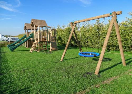 a playground with two swings and a slide at Kings Lynn Holiday Park in King's Lynn