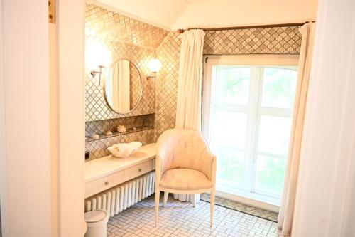 a bathroom with a chair and a sink and a window at Landsitzhotel und Seminarium Peterhof in Hodorf