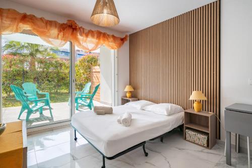 - une chambre avec un lit et deux chaises bleues dans l'établissement Studio dans résidence neuve - Terrasse et jardin, à Cannes