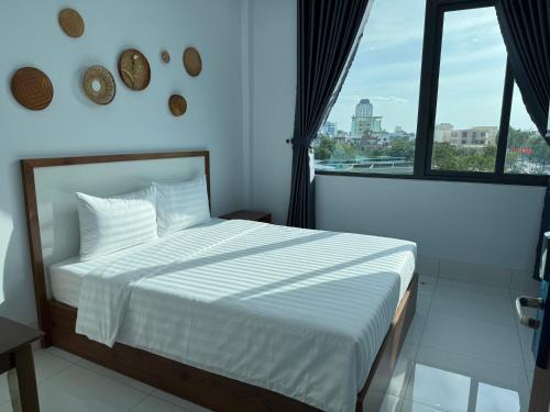 a bedroom with a bed with a view of a city at An Nhiên Hotel in Tây Ninh