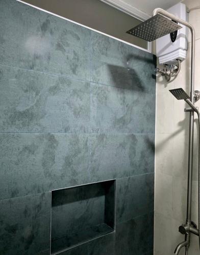 a bathroom with a shower with a stone wall at Mamadear's Bed & Breakfast in Suizo