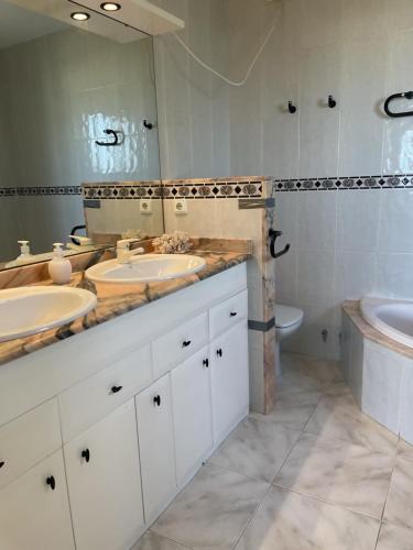 a bathroom with two sinks and a tub and a toilet at Ola Somhome in Peniscola