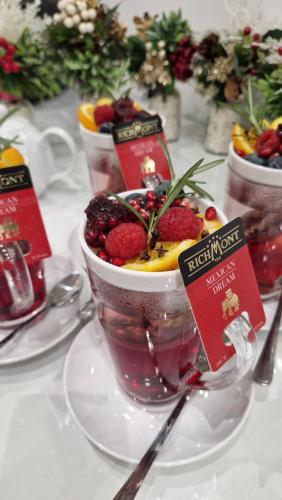 a table topped with a cup of dessert with strawberries and fruit at Willa Jelonka in Jelenia Góra