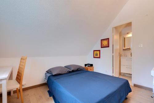 a bedroom with a blue bed and a desk at Alpazur 2 - Proche des remontées mécaniques in Gréolières