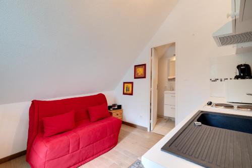 - un canapé rouge dans une chambre avec cuisine dans l'établissement Alpazur 2 - Proche des remontées mécaniques, à Gréolières