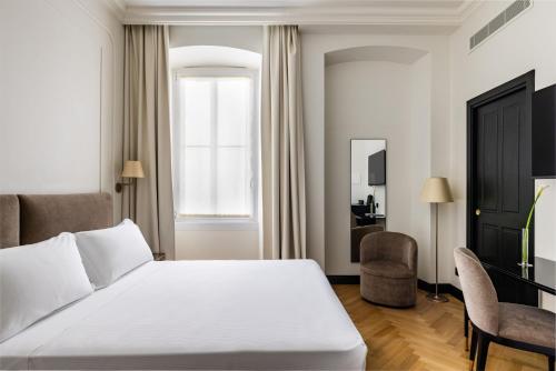 a bedroom with a white bed and a window at Hotel Continentale in Trieste
