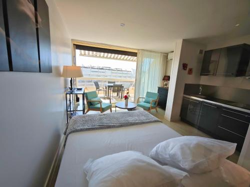 une chambre avec un lit et une table avec des chaises dans l'établissement Studio Desobeissance Village Naturiste, au Cap d'Agde