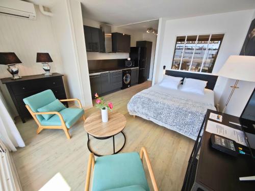 une chambre avec un lit, une table et des chaises dans l'établissement Studio Desobeissance Village Naturiste, au Cap d'Agde