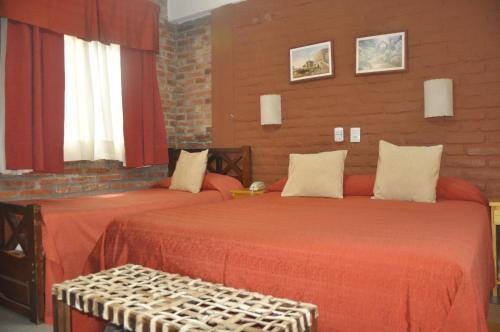 a bedroom with two beds with red sheets at Termas Del Sol in Termas de Río Hondo