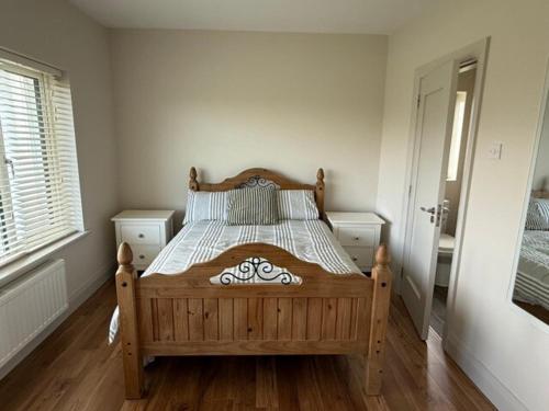 a bedroom with a wooden bed in a room at Carhan River Holiday Home - Cahersiveen in Cahersiveen