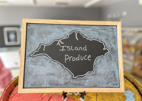 a chalkboard with the name of island produce on it at Orchards Holiday Park in Newbridge