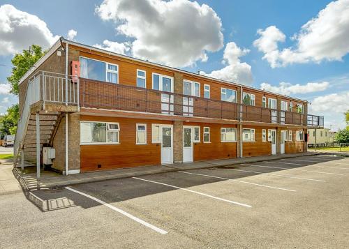 a building in a parking lot with a balcony at North Shore Holiday Park in Winthorpe