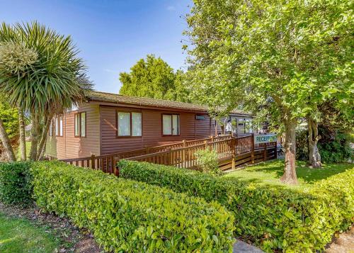 a house with a wooden deck in a yard at North Shore Holiday Park in Winthorpe