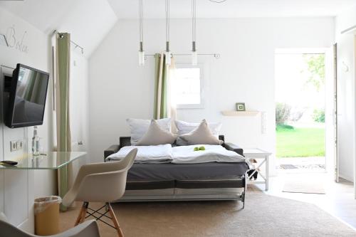 a bedroom with a bed and a table and a tv at Landsitzhotel und Seminarium Peterhof in Hodorf