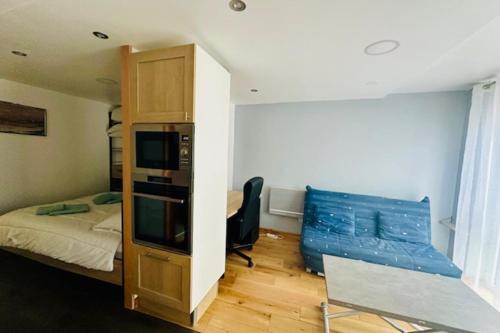 - une petite chambre avec un lit et un canapé bleu dans l'établissement Ideal location for this pleasant studio, à La Rochelle