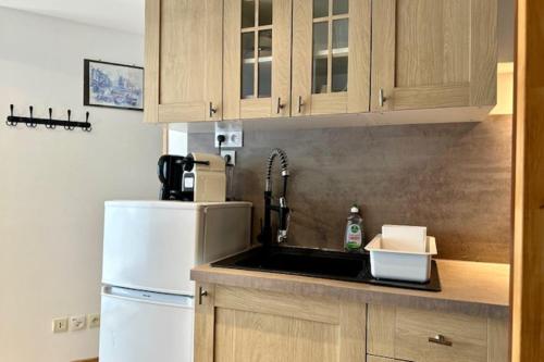une cuisine avec un évier et un réfrigérateur blanc dans l'établissement Ideal location for this pleasant studio, à La Rochelle